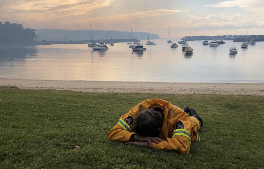 HEROES: An exhausted firefighter catches some sleep on the NSW South Coast.