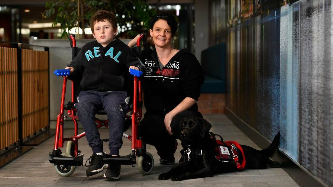 Kayle Griffin, 12, mum Christy Cook and his assistance dog Luna during a training outing at Stockland Wendouree. Photo: Adam Trafford