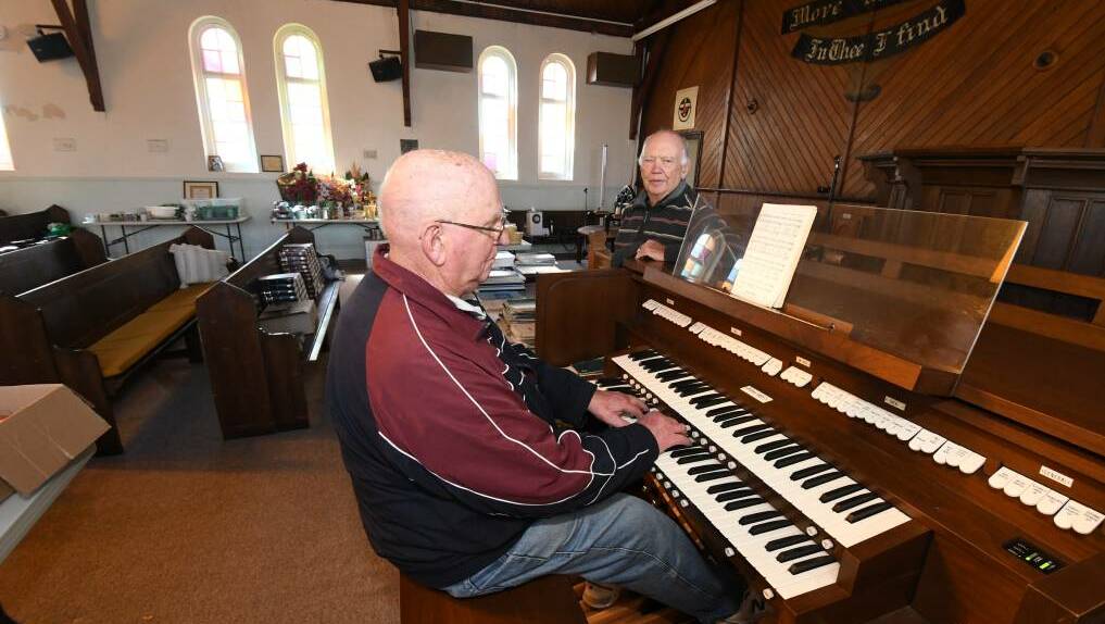 Richard Dutton plays the Five Ways church organ which is up for sale as part of the clearance as Ken Allen looks on. Photo: JUDE KEOGH 0509jkchurch1