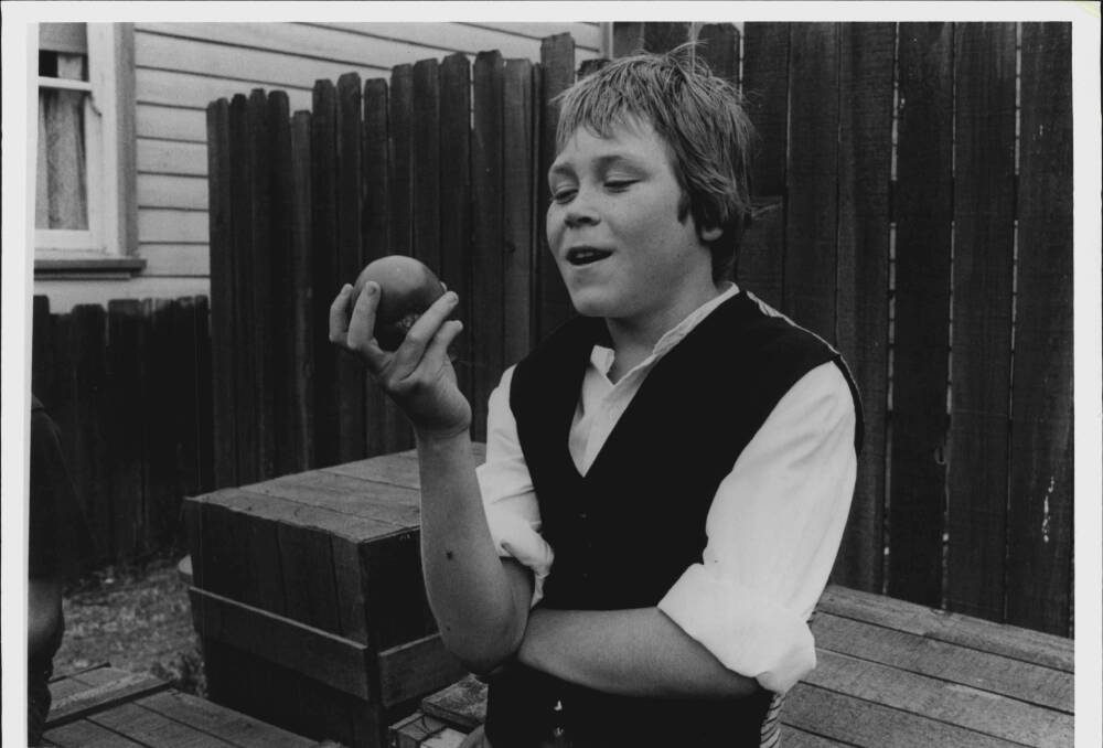 Ginger (Paul Daniel) hefts a ripe tomato which he plans to throw at Tiger Kelly (Drew Forsythe) in a scene from Ginger Meggs.