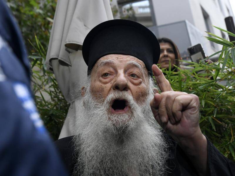 A Greek orthodox priest is carried away by police after he heckled visiting Pope Francis.