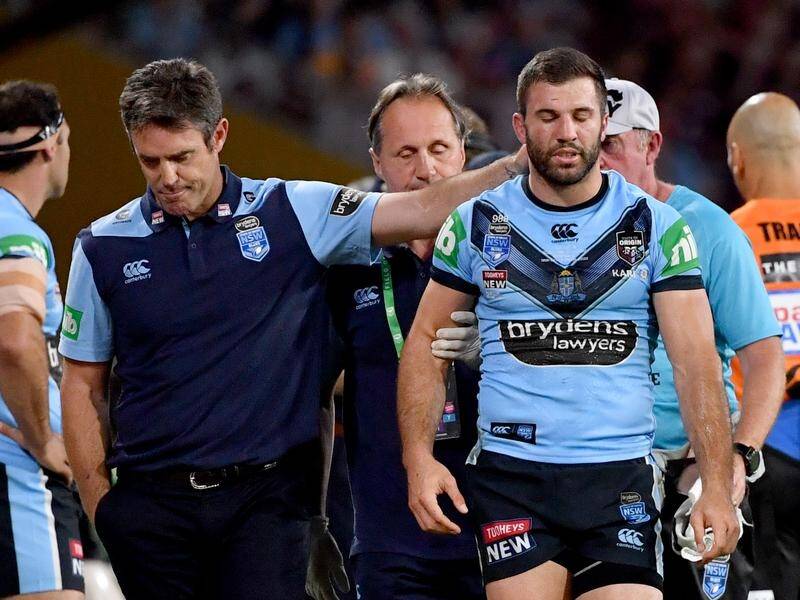 NSW coach Brad Fittler (l) assists James Tedesco after he was taken from the field.